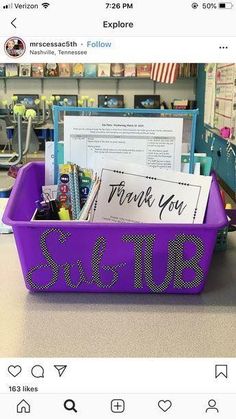 a purple plastic container filled with lots of writing on top of a counter next to a sign that says thank you