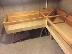 three wooden trays sitting next to each other on top of a cement floor in a room