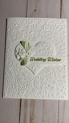 a white wedding card with a heart on it