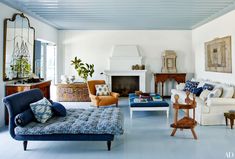 a living room filled with furniture and a fire place in the middle of the room