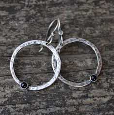 "🌟PLEASE READ the following description before making your purchase.  Note measurements and size reference photos. Black onyx sterling silver hammered hoop dangle earrings Tiny 3mm black onyx stones are set in pure silver bezels on rustically hand shaped, hammered, and oxidized 1\" sterling circles dangling from comfortable french style ear wires.  Lightweight and easy to wear!  Total length 1 ½\"" Adjustable Oxidized Hoop Earrings, Small Sterling Silver Hoop Earrings With Oxidized Finish, Sterling Silver Oxidized Hoop Earrings, Black Handmade Sterling Silver Hoop Earrings, Silver Onyx Drop Earrings, Style Français, Black Onyx Stone, Onyx Stone, Hammered Silver