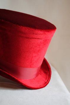 The Dandy is a simple and yet elegant victorian inspired top hat.It is covered with soft rich velvet in wine red.It is elegantly embellished with matching colored ribbon around the crown. Available in black, red(pictured) or ivory with matching ribbon. Need this TOP HAT in another color? with more decoration? Just send me a message to talk about a custom hat made just for you! This hat is fully lined with satin and it is made to according to your exact head measurement making it suitable for bot Elegant Red Top Hat For Winter, Vintage Red Hat For Costume Party, Vintage Red Hats For Costume Party, Red Vintage Costume Hat, Red Fitted Hat For Costume, Red Costume Hat, Red Fitted Vintage Top Hat, Classic Red Fitted Top Hat, Vintage Red Brimmed Top Hat