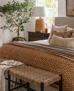 a bed sitting next to a window in a room with a lamp on top of it