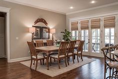 a dining room table and chairs in front of sliding glass doors