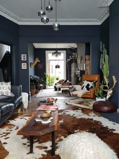 a living room filled with furniture and lots of cow hide rugs on the floor