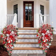 two christmas wreaths on the front steps of a house