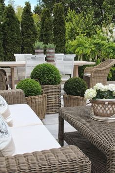 wicker patio furniture with white flowers and greenery