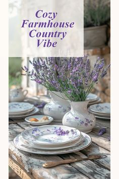 a table topped with plates and vases filled with purple flowers on top of it