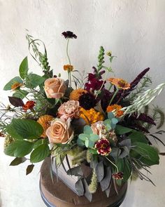 a vase filled with lots of flowers on top of a table