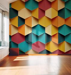 a room with wooden floors and colorful wallpaper on the walls that is designed like hexagonal cubes