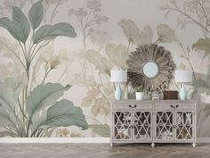 a white dresser sitting next to a mirror on top of a wooden floor in front of a floral wallpaper