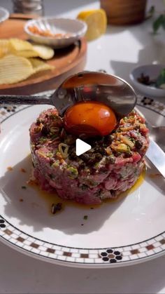 a piece of meat is being prepared on a plate with a ladle and sauce