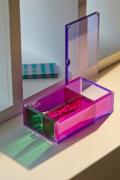 a pink and purple box sitting on top of a window sill