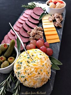 an assortment of cheeses, meats and vegetables on a platter