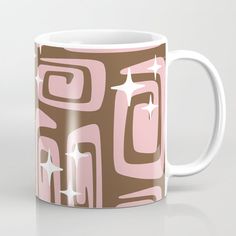 a pink and brown coffee mug with white stars on the top, sitting on a table