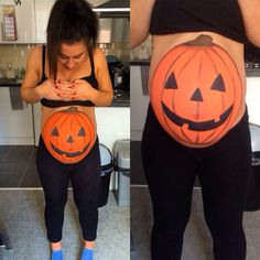 a pregnant woman wearing halloween pumpkins on her stomach