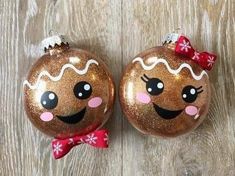 two christmas baubles with faces painted on them, one has a bow and the other has snowflakes