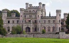 an old castle sitting on top of a lush green field