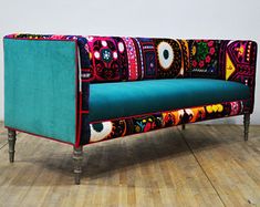 a colorful couch sitting on top of a wooden floor