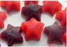 red and purple star shaped candies on a white surface