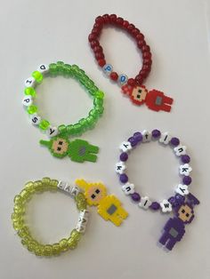 four different bracelets with beads and charms on top of a white surface, each featuring an image of the same character