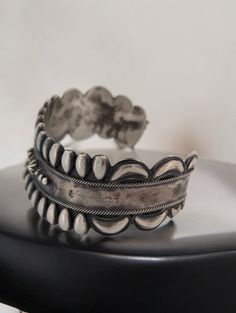 Celebrate the rich heritage of Native American craftsmanship with this vintage sterling silver cuff bracelet, a handmade treasure that exudes both strength and beauty. Stamped with a distinctive bear symbol and "RB", along with the .925 sterling silver mark, this piece is a stunning example of artistry and tradition. The repousse style design, enhanced by hand-stamped details and twisted wire accents, makes this bracelet a standout in any collection. Material: Authentic .925 sterling silver, guaranteeing high quality and durability. Design: Features a repousse style design with intricate hand-stamped details and twisted wire accents for added texture and dimension. Stamping: Bears a unique bear stamp with "RB" inside, a mark of Native American craftsmanship, alongside the .925 stamp for st Bear Symbol, Twisted Wire, Sterling Silver Cuff Bracelet, Sterling Silver Cuff, Silver Cuff Bracelet, Native American Jewelry, Silver Cuff, Vintage Accessories, Style Design