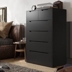 a living room with a couch, chair and chest of drawers