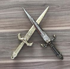 two swords are sitting side by side on a table