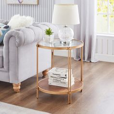 a living room with a couch, coffee table and books on the end tables in front of it