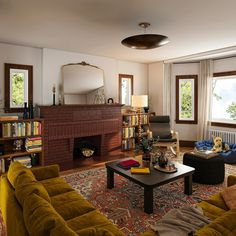 a living room filled with furniture and a fire place in the middle of a room