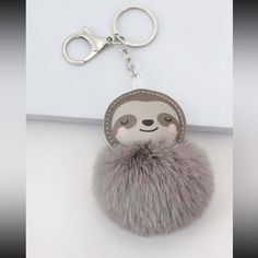 a slotty keychain with a furry ball hanging from it's side