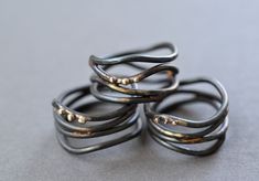 Organic wrap rings, reminiscent of vines,  are fabricated from forged steel wire that has been brazed together with brass and accented with small beads of recycled 10k gold.  Available in whole and half sizes, 4-11.  Rings are around 12mm across at their widest point.  Note Because of the width of the rings its recommended to order a half size larger than you normally would. Due to the handmade nature of these rings, each one is unique and exact design will vary from the photo. Steel has been se Invoice Layout, Wrap Around Ring, Interlocking Circle Necklace, Gold Circle Necklace, Blackened Steel, Wire Ring, Small Beads, Wide Ring, Ring Hand