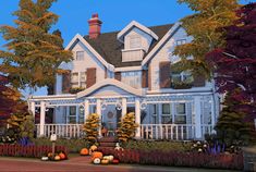 a large blue house surrounded by trees and pumpkins