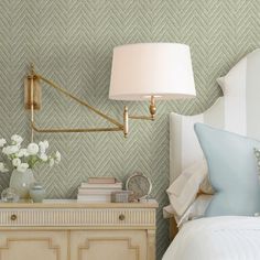 a bedroom with green wallpaper and white bedding