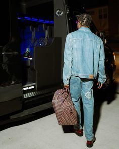 a man with a bag walking towards a vehicle