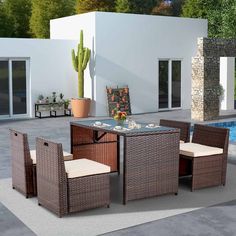 an outdoor dining table with four chairs next to a pool