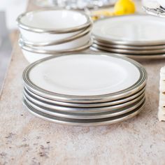 a stack of white plates sitting on top of a counter