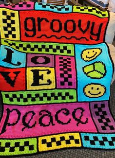 a crocheted afghan with the words grooy on it and smiley faces