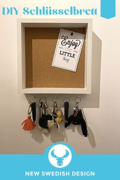 a cork board with keychains hanging from it