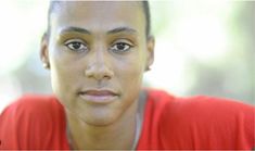 a close up of a person wearing a red shirt and looking at the camera with a serious look on his face