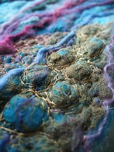 a close up view of some yarns on a table cloth with blue and pink colors