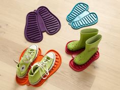 four pairs of shoes are sitting on the floor next to each other, with different colors and sizes