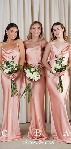 three bridesmaids in pink gowns posing for a photo with their bouquets