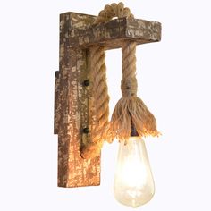 a light that is hanging from a wooden beam and has rope wrapped around the bulb