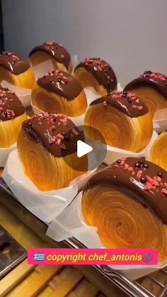 cupcakes with chocolate frosting and sprinkles are on display at a bakery