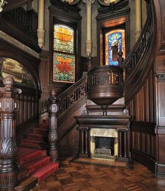 an ornate victorian home with red stairs and stained glass windows in the entryway to the second floor