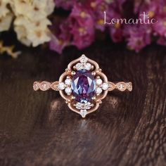 a close up of a ring on a wooden surface with flowers in the back ground