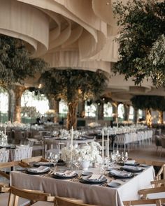 the tables are set with place settings and centerpieces for an elegant wedding reception