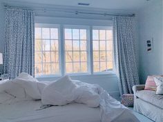 a white bed sitting under a window in a bedroom