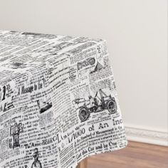 a table covered with newspaper paper on top of a hard wood floor next to a white wall